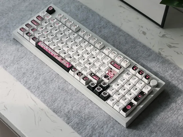 White Q98 Chibi Haruka keyboard photographed on a gray desk mat with black and pink character keycaps