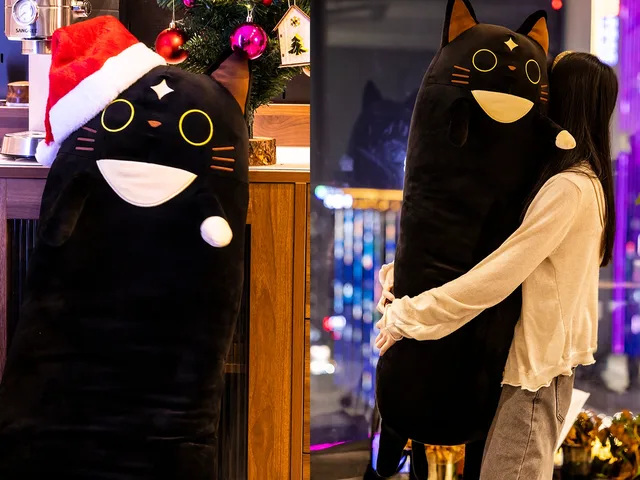 Oversized Cafemi plush wearing a Santa hat and being held